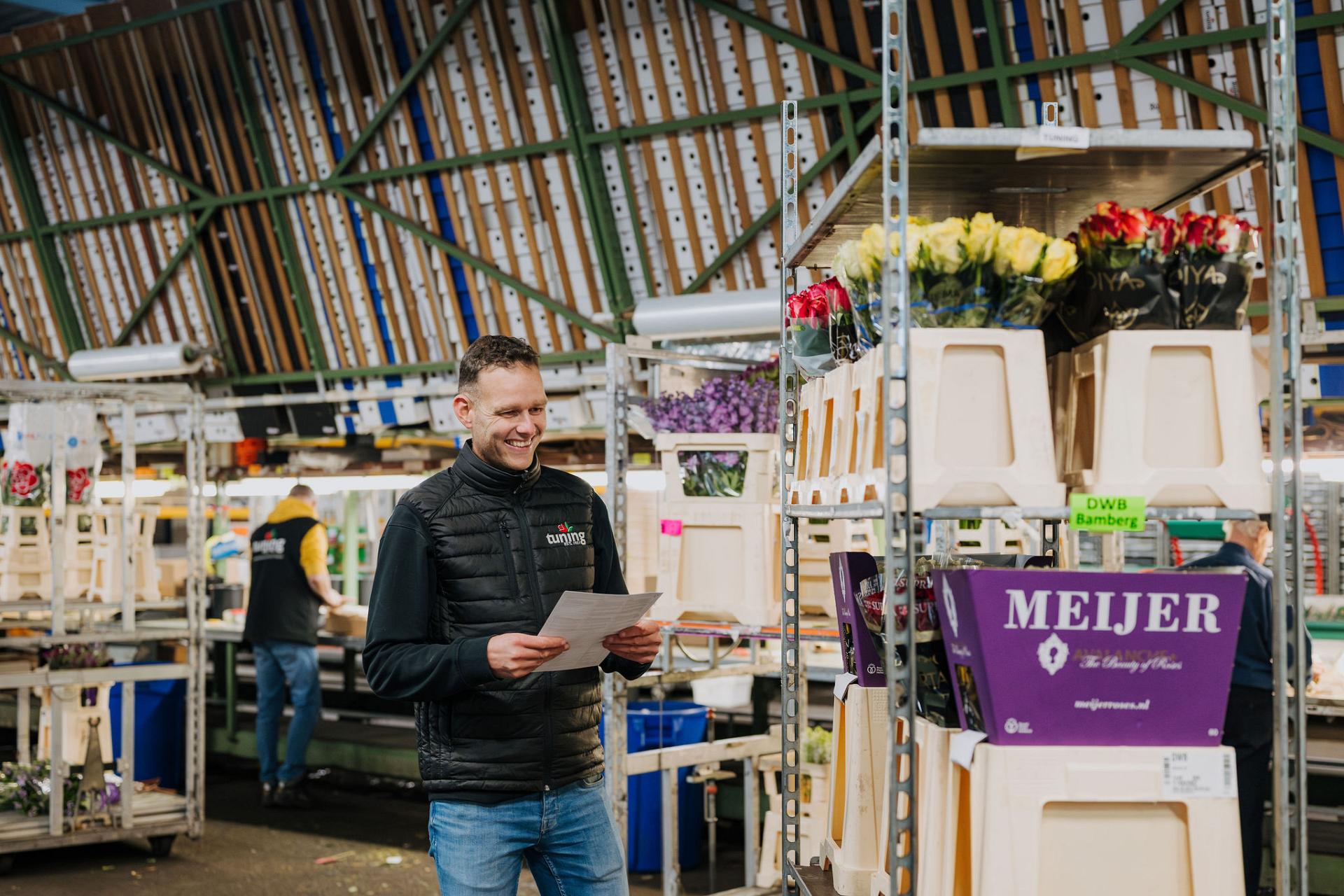 Medewerker van Tuning controleert orders in de bloemenhal, om een nauwkeurige afhandeling en tijdige levering te waarborgen.