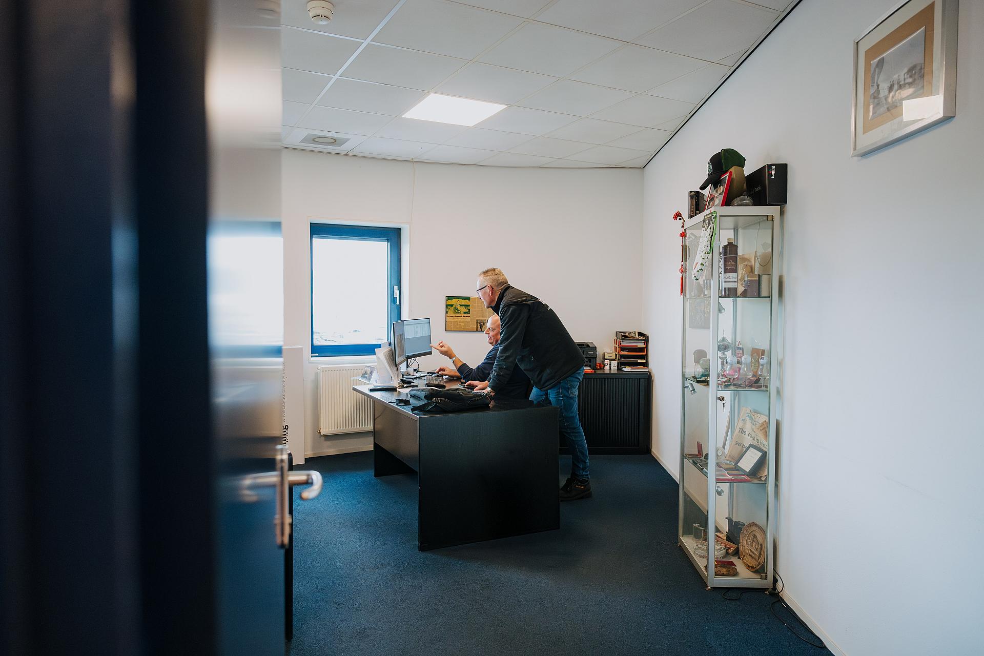 Medewerker van Tuning werkt geconcentreerd aan zijn bureau op kantoor, bezig met dagelijkse administratieve en organisatorische werkzaamheden.