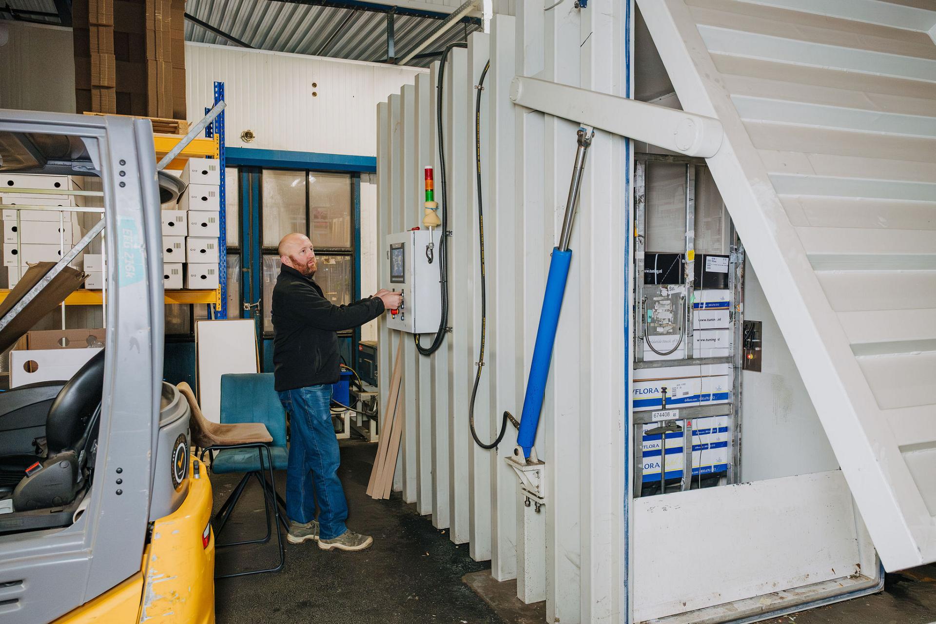 Mitarbeiter von Tuning bedient eine industrielle Anlage im Logistikbereich, als Teil des automatisierten Verarbeitungsprozesses.